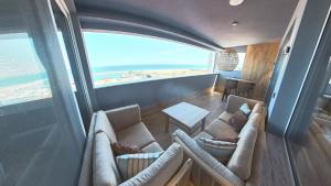 a living room with two couches and a view of the ocean at Poseidon Girni Sea View Apartments in Paralia Katerinis