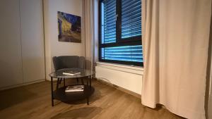 een kamer met een stoel, een tafel en een raam bij NEW STYLISH APARTMENT Varta Alpha 2025 & Parking in Praag
