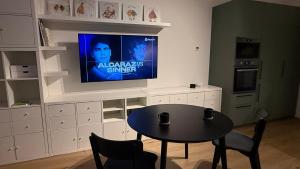 een keuken met een tafel en een tv aan de muur bij NEW STYLISH APARTMENT Varta Alpha 2025 & Parking in Praag