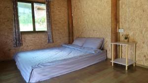 een slaapkamer met een bed in een kamer met een raam bij Chanya homestay in Ban Yang