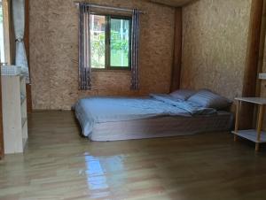 een slaapkamer met een bed in een kamer met een raam bij Chanya homestay in Ban Yang +3 foto's