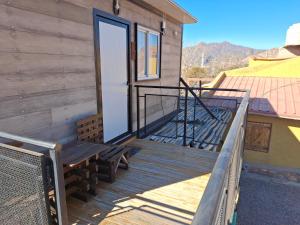 a wooden deck with a door on a house at Cabañas Soledad in Potrerillos