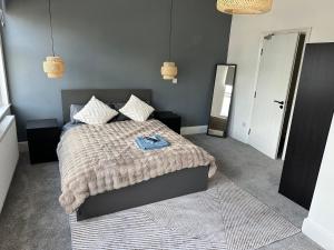 een slaapkamer met een bed met een deken en een spiegel bij Norton Rd Guest House in Stockton-on-Tees