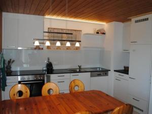 a kitchen with a wooden table and a wooden dining table at Apartment Chalet Hofer by Interhome in Hasliberg Wasserwendi