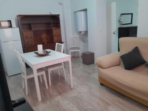 een woonkamer met een witte tafel en een bank bij Aurora2 Alcazar - Alojamiento en centro histórico in Úbeda