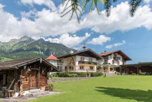 a house in the mountains with a green lawn at S'Hoamatl in Hofen