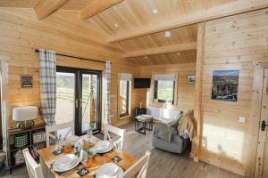 a dining room and living room of a log cabin at Glenview Log Cabin in Ballycastle