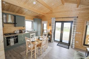 a kitchen and dining room with a table and chairs at Glenview Log Cabin in Ballycastle