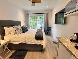 een slaapkamer met een bed, een bureau en een raam bij 55 Albatross Guesthouse in Sandton