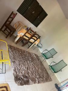 a room with a table and chairs and a rug at Casa Aurora in Chapada dos Guimarães