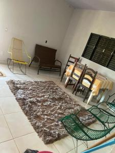a living room with chairs and a rug at Casa Aurora in Chapada dos Guimarães