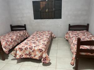 two beds sitting next to each other in a room at Casa Aurora in Chapada dos Guimarães