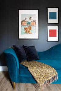 a blue couch in a living room with pictures on the wall at Kasa Edison House South End Dilworth Charlotte in Charlotte +8 photos