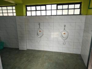 two urinals on a tiled wall in a bathroom at Sirimon Base Camp in Nanyuki +35 photos