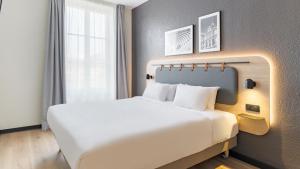 een slaapkamer met een groot wit bed in een kamer bij Campanile PRIME - Lyon Centre - Gare Perrache in Lyon +55 foto's