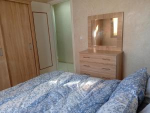 a bedroom with a bed with a dresser and a mirror at Cozy and Comfortable Apartment in Agadir