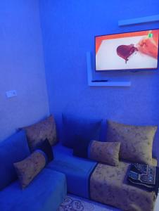 a blue living room with a couch with pillows at Cozy and Comfortable Apartment in Agadir
