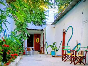 a white building with colorful chairs and a red door at Fauna in Santa Marta
