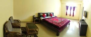 a bedroom with a bed with a purple bedspread at D'Bonn Inn in Shillong