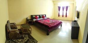 a bedroom with a bed and a tv in a room at D'Bonn Inn in Shillong