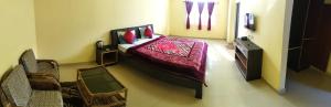 a bedroom with a bed with a red bedspread at D'Bonn Inn in Shillong +5 photos
