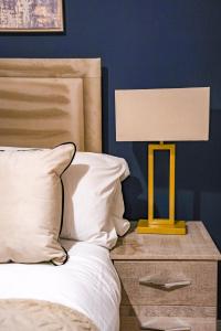 een gele lamp op een nachtkastje naast een bed bij Mayfield House in Newtongrange
