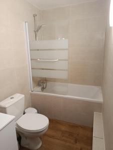 ein weißes Badezimmer mit Toilette und Badewanne in der Unterkunft Appart'Hotel Lizon Cocooning avec sauna in Lavans-lès-Saint-Claude