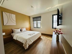 a bedroom with a bed and two windows at Shining Hotel Son La in Bản Bố Pua