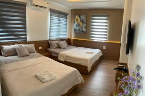 a bedroom with two beds and a flat screen tv at Shining Hotel Son La in Bản Bố Pua
