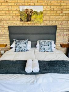 En eller flere senge i et værelse på Elephant Lodge - Sundays River Cottages - Addo Park South - only 5 min