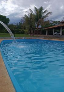 a pool with a fountain in the middle at Sítio flor do campo 7L in Sete Lagoas