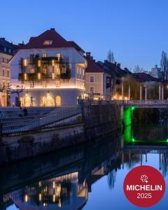 a building next to a river at night at Zlata Ladjica Boutique Hotel in Ljubljana