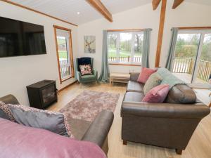 a living room with a couch and a chair at Cedar Lodge in Rugeley