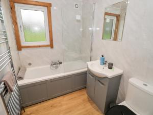 a bathroom with a tub and a sink and a shower at Cedar Lodge in Rugeley