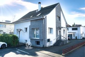 une maison blanche avec un toit noir dans l'établissement Modern Station Apartment Mhlin, à Möhlin