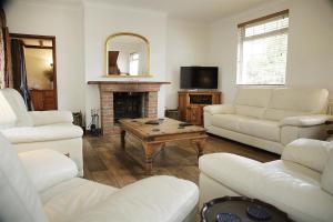 a living room with white furniture and a fireplace at 4 Bed in Penmaen oc-hh86 in Nicholaston