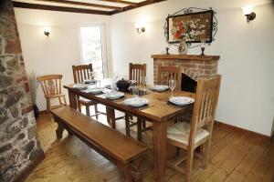a dining room with a wooden table and a fireplace at 4 Bed in Penmaen oc-hh86 in Nicholaston