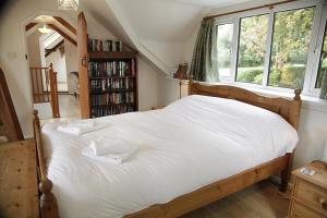 a bedroom with a large white bed with a window at 4 Bed in Penmaen oc-hh86 in Nicholaston