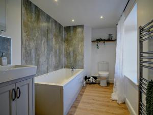 een badkamer met een bad, een wastafel en een toilet bij 3 Bed in Llandefalle 93680 in Llandefalle +30 foto's