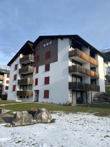 ein Gebäude mit Balkonen an der Seite eines Wasserkörpers in der Unterkunft Satin Home in Savognin