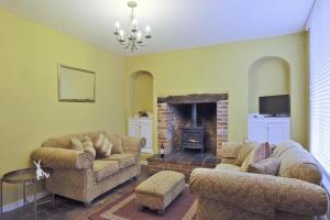 een woonkamer met twee banken en een open haard bij 2 Bed in Eye oc-4lamb in Eye