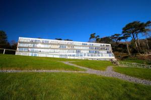 a large white building on a grassy field at 2 Bed in Gower oc-hh919 in Bishopston