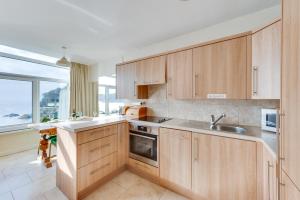 a kitchen with wooden cabinets and a sink and a window at 2 Bed in Gower oc-hh919 in Bishopston +7 photos