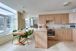 a kitchen with a wooden table and green chairs at 2 Bed in Gower oc-hh919 in Bishopston