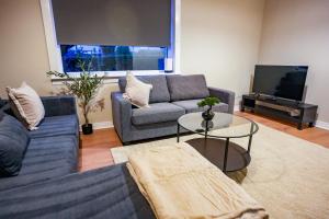 a living room with two couches and a tv at Mayfield House in Dalkeith