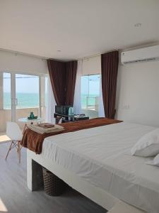 a bedroom with a large bed with a view of the ocean at Inuli Coco Hut in Kalutara