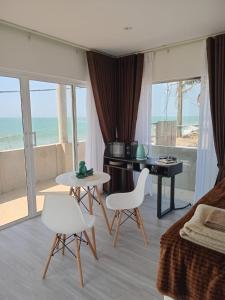 a bedroom with a bed and a table and chairs at Inuli Coco Hut in Kalutara