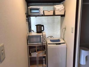 a small kitchen with a stove and a microwave at PhaseSpace in Sekimachi +3 photos