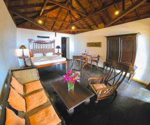 een woonkamer met een bank, stoelen en een tafel bij Villa Kusum in Hikkaduwa