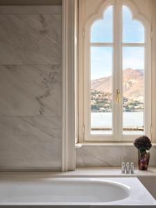 a bathroom with a white tub and a window at Palazzo Venezia in Como